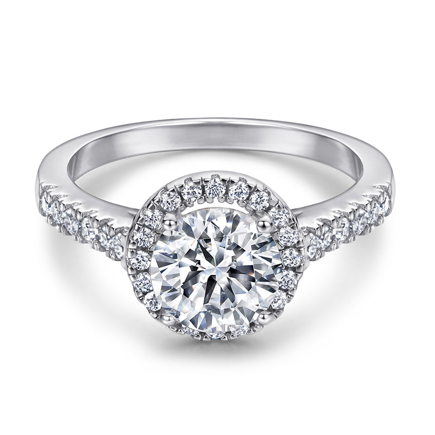 Silver ring with a large central diamond and smaller diamonds around on a white background