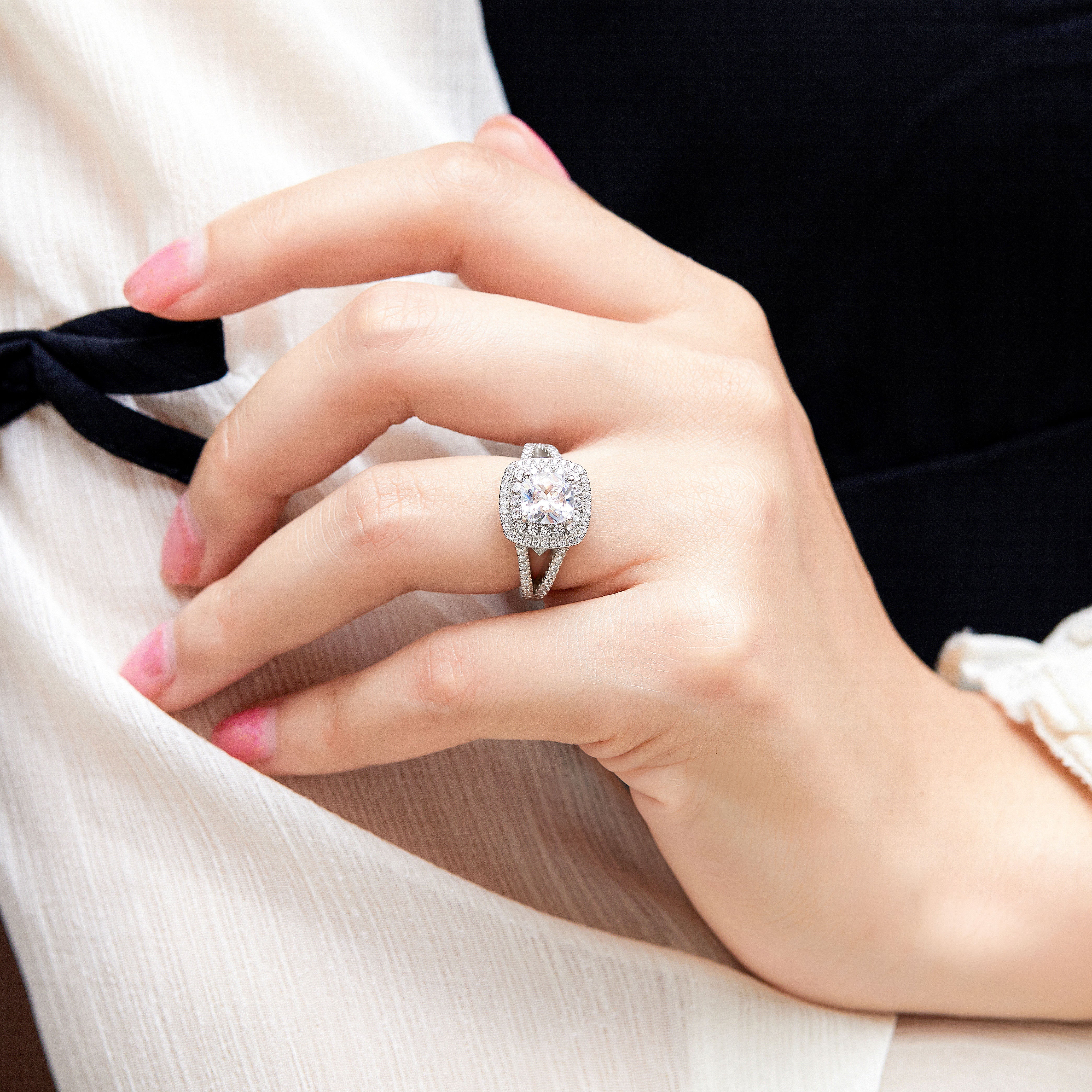 Close-up of a hand wearing a diamond ring with a blurred background