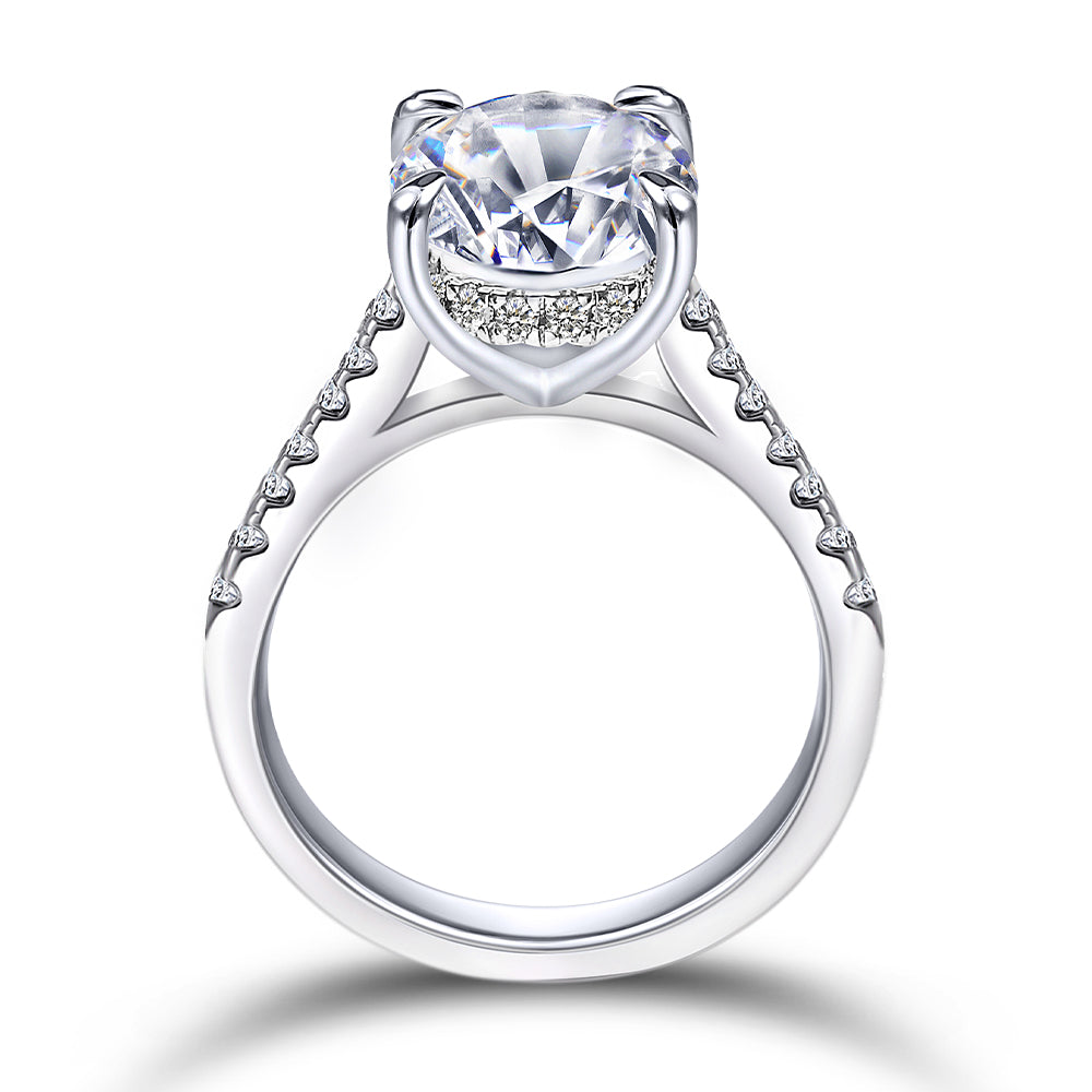 Silver ring with a large central diamond and smaller diamonds on the band against a white background