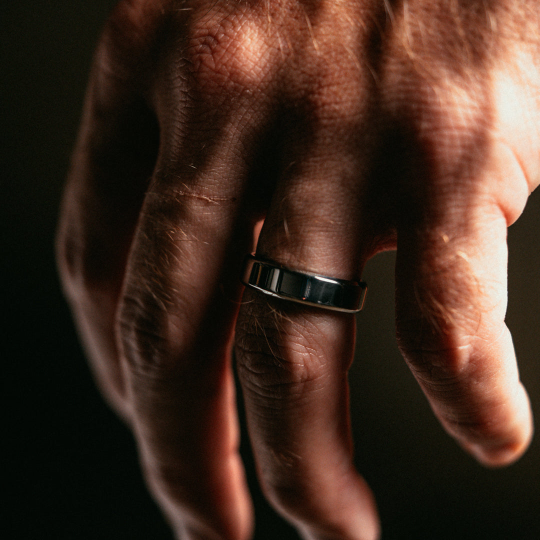 Hand with a ring on a dark background