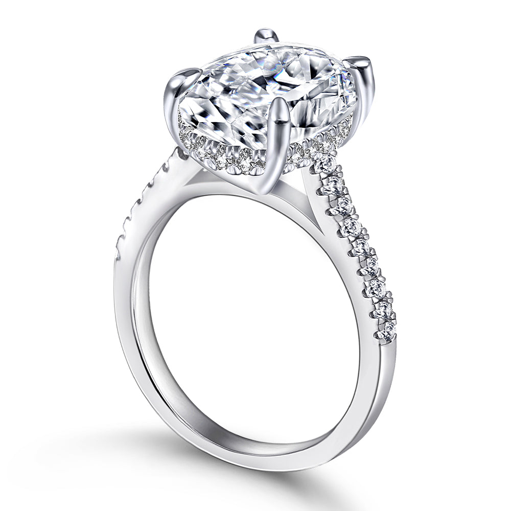 Silver ring with a large diamond and smaller diamonds on the band against a white background
