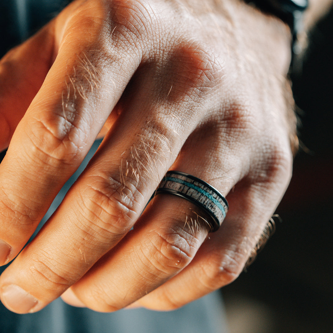 Close-up of a hand wearing a ring with a blurred background