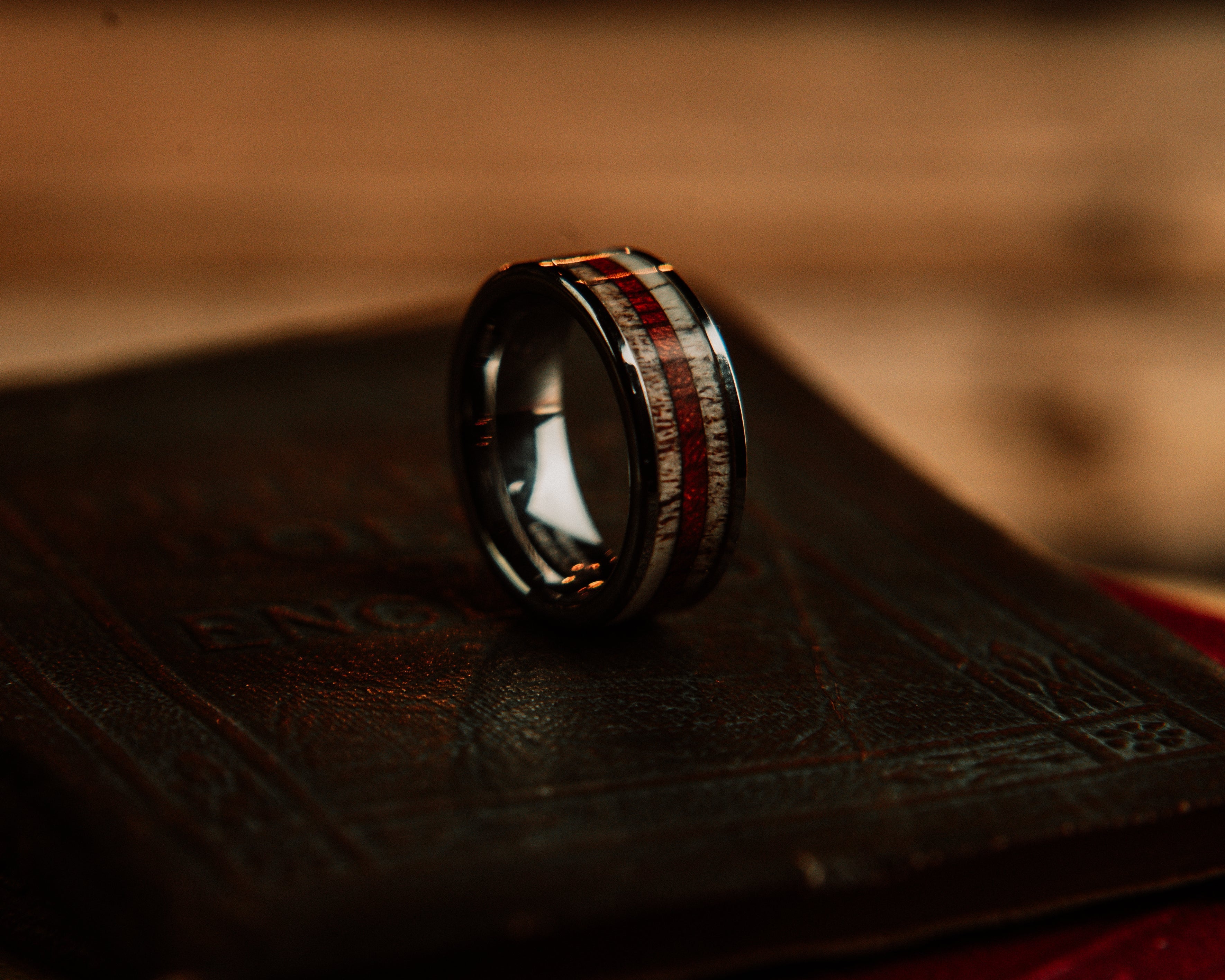 Wooden ring with inlaid pattern on a textured surface
